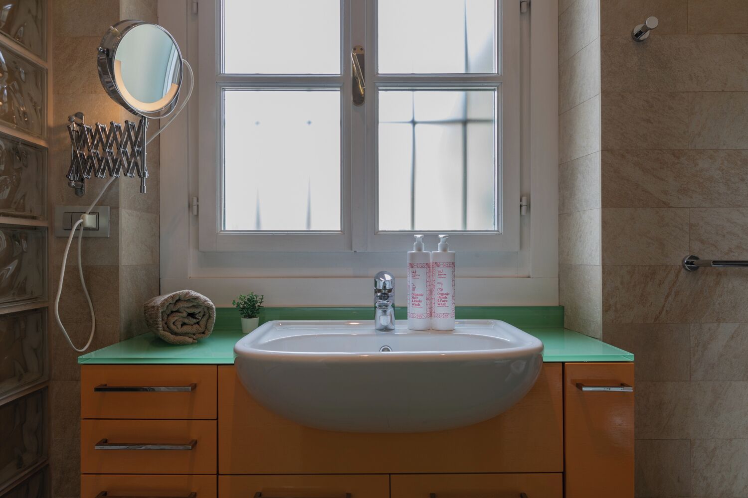 Een badkamer met een wastafel, spiegel en toiletartikelen.