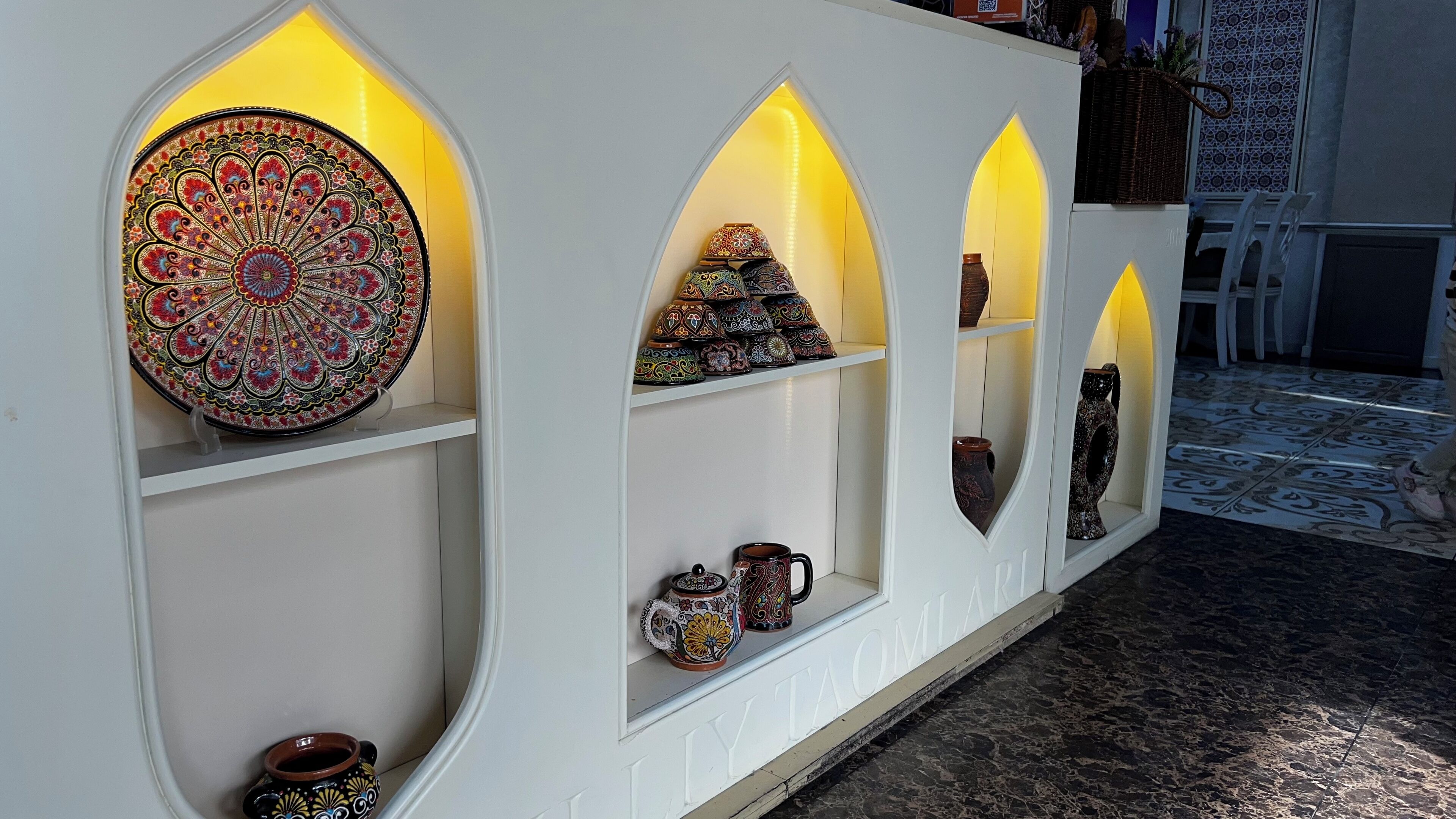 A display of intricately designed pottery and ceramics in a well-lit, white interior space.