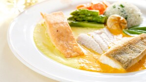 Un plato de comida con pescado, verduras y arroz.