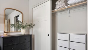 A room with a white wardrobe, a black dresser, and a mirror.