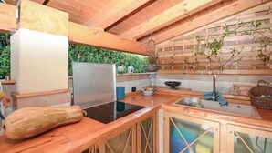 Eine Küche mit Holzschränken, einem Edelstahlkühlschrank und einem eingebauten Herd.
