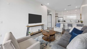 Un salon moderne avec un canapé, une table basse et un téléviseur fixé au mur.