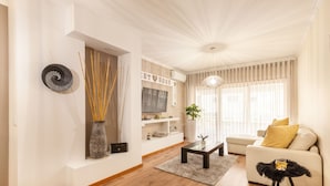 A modern living room with a sofa, a coffee table, and a TV.