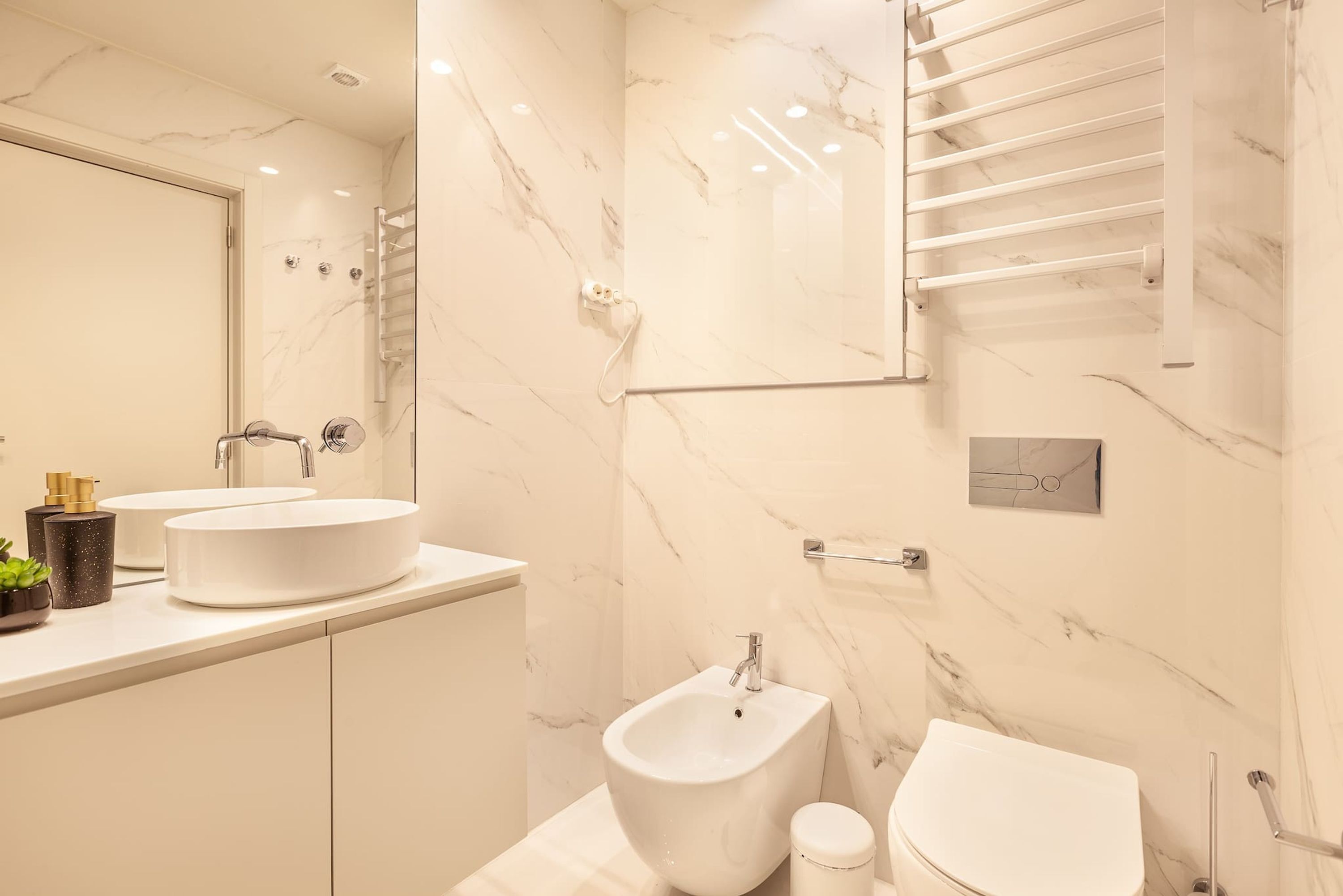 Un baño moderno con dos lavamanos, un bidé y un inodoro.