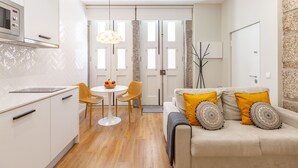 Una cocina moderna con armarios blancos, un microondas y un comedor con mesa y sillas.