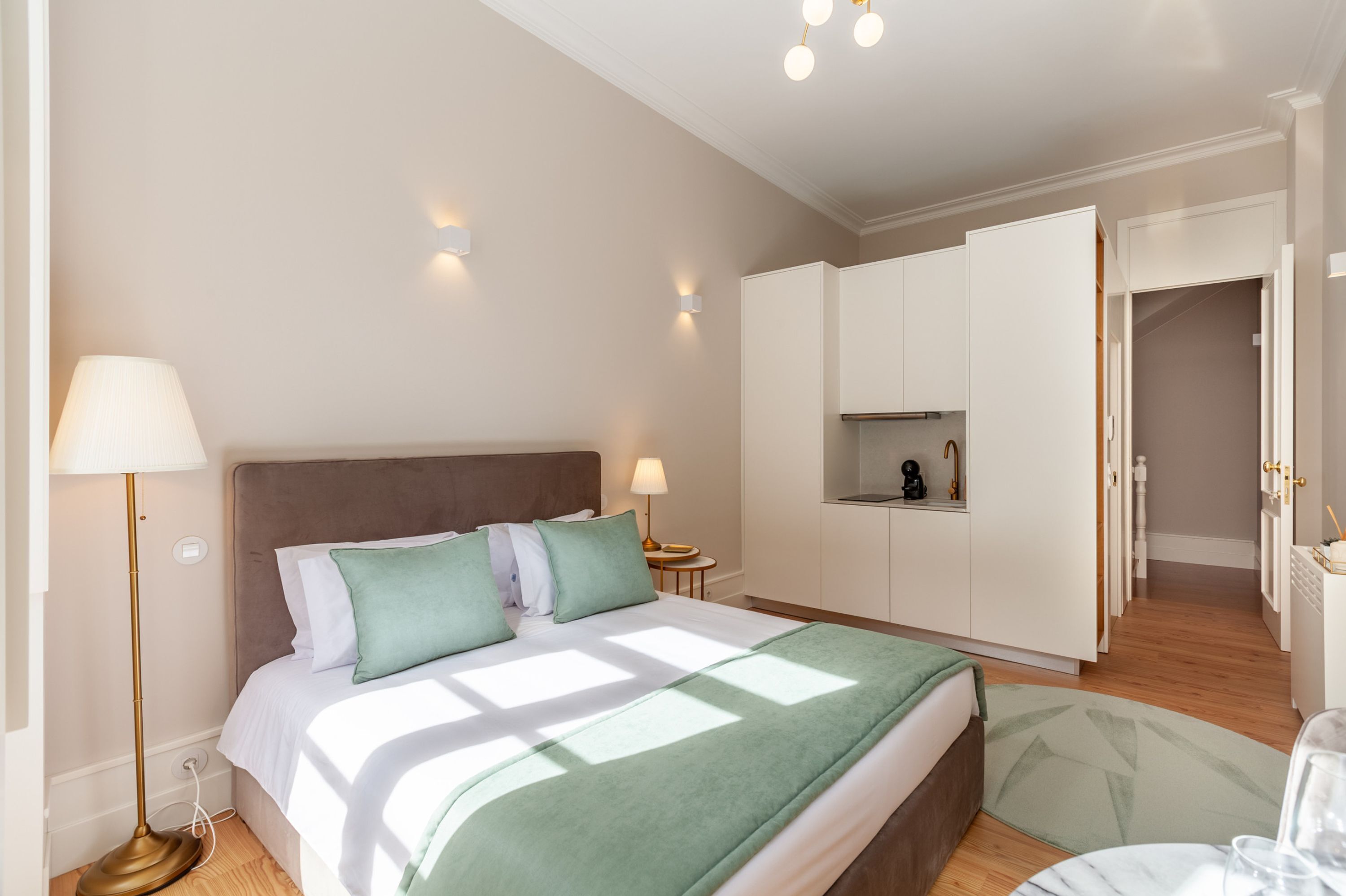 A bedroom with a bed, bedside lamps, a nightstand, and a built-in wardrobe.