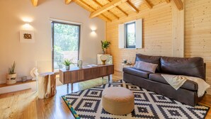 Un salon moderne avec un plafond en bois, un canapé en cuir marron, un tapis à motifs et un buffet en bois.