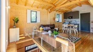 Une cabane en rondins moderne, avec un intérieur en bois, un coin repas et une cuisine.