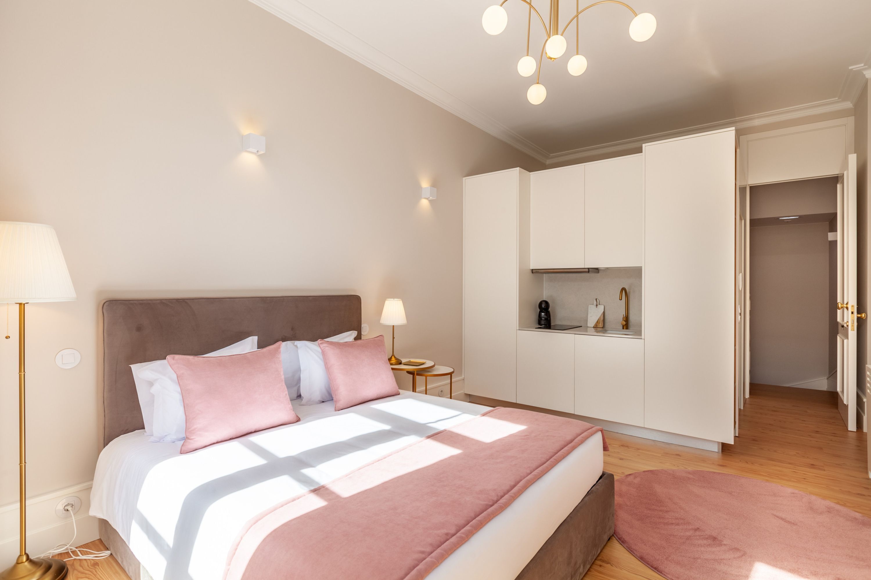 Ein Schlafzimmer mit Bett, Nachttischlampen, einem Kleiderschrank und einem kleinen Tisch.