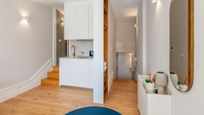 A modern kitchen with white cabinets, a wooden countertop, and a built-in oven. - Living Valverde Studio Azul - Minho s Guest (Braga)