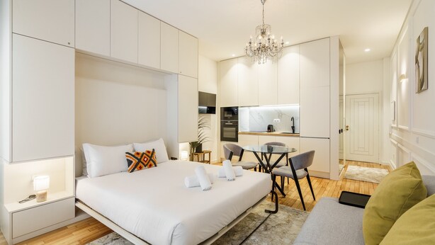 A modern hotel room with a large bed, a desk, and a kitchenette. - Ch os Concept By Minhos Guest (Braga)