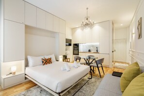 Ein modernes Hotelzimmer mit einem großen Bett, einem Schreibtisch und einer Küchenzeile.