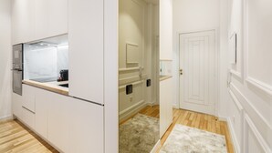 A modern kitchen with white cabinetry, a marble countertop, and a built-in oven. - Ch os Concept By Minhos Guest (Braga)