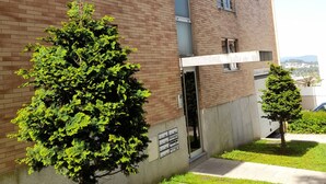 A multi-story brick building with a small tree in the foreground and another in the background. - Machado s Lodge - Minho s Guest (Braga)