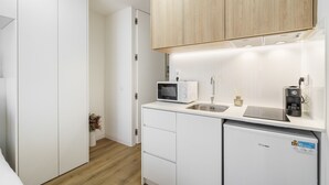 A compact kitchen with white cabinetry, a microwave, a sink, and a mini refrigerator. - Santa Barbara Flat by Minhos Guest (Braga)