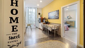 Um interior de casa com cozinha, sala de jantar e um quarto.