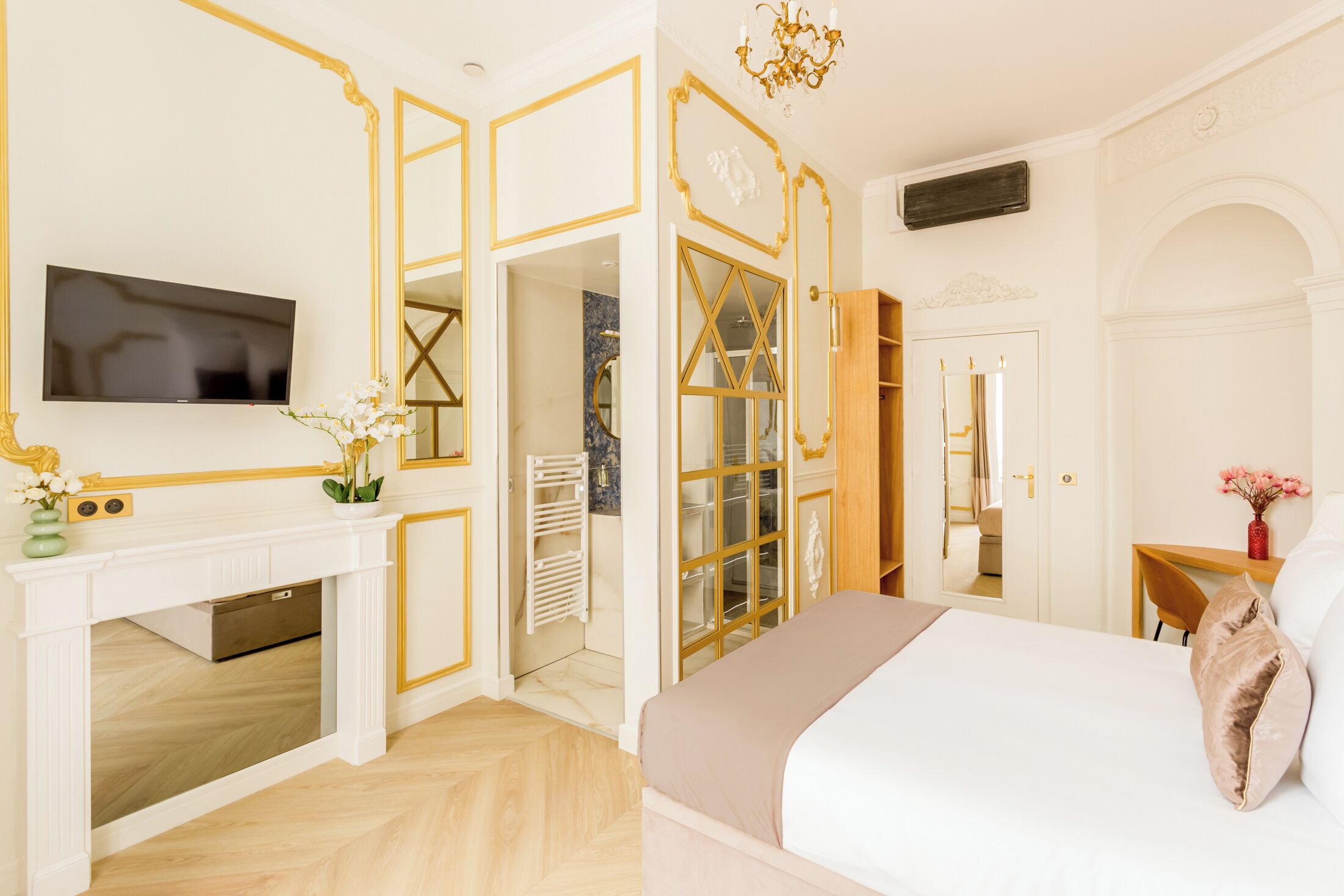 Une chambre à coucher avec un lit, une télévision, une cheminée et un dressing.