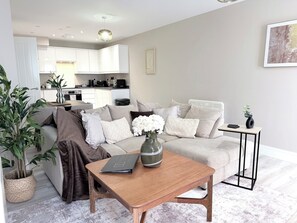 A modern living room with a sofa, a coffee table, and a potted plant. - Toast Stays - The Oakley at Parsons House (Washington)