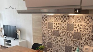 A modern kitchen with a wooden countertop, a black induction cooktop, and a patterned backsplash. - Apartment center, Timone/Stade vélodrome (Marseille)