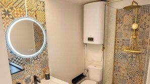 A bathroom with a wooden vanity, a white sink, a toilet, and a shower with a glass enclosure. - Apartment center, Timone/Stade vélodrome (Marseille)