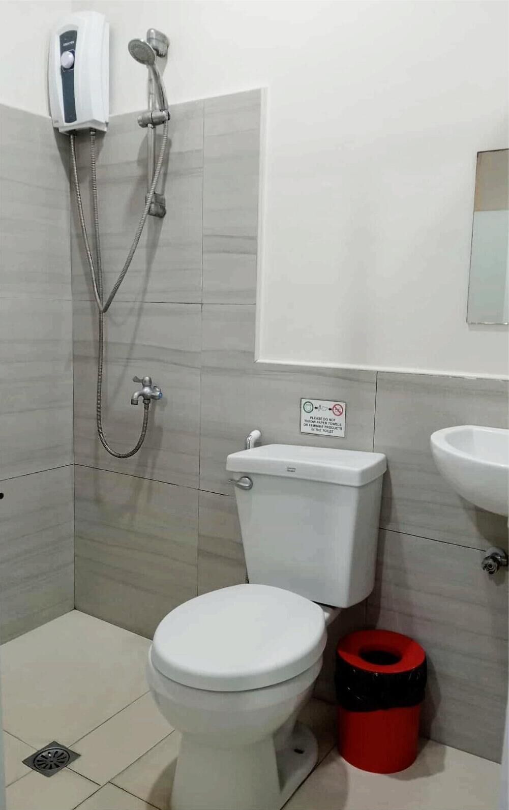 Une salle de bain avec des toilettes, une douche et un lavabo.