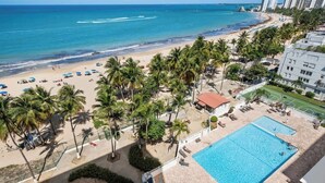 Ein Hotel am Strand mit Swimmingpool, Palmen und Blick auf den Ozean.