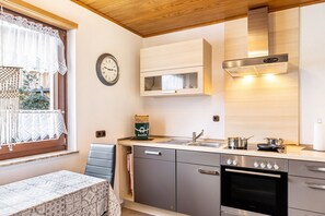 A modern kitchen with a built-in oven, a microwave, and a stainless steel range hood. - Holiday Apartment 'Göpfert' with Wi-Fi (Ebersburg-Weyhers)