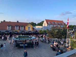 A bustling outdoor market with food stalls and a crowd of people. - 5 Star Holiday Home in Vaeggerlose (Vaeggerlose)