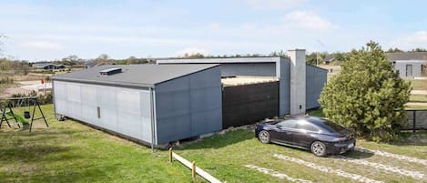 A modern building with a garage and a car parked in front.