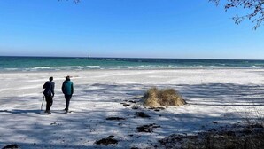 A beach with two people standing, a clear sky, and the ocean in the background. - 5 Star Holiday Home in Nexo (Nexø)