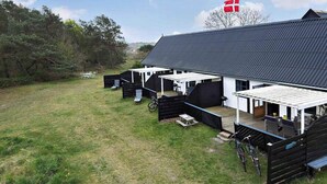 A stable with a covered riding area, a flag, and a grassy field. - 5 Star Holiday Home in Nexo (Nexø)