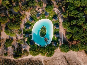 An aerial view of a resort with a central swimming pool surrounded by guest rooms and lush greenery. - Chalet do Lago (Ponte de Sor)