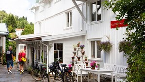 Un bâtiment blanc avec une enseigne indiquant « Stuggesen Jensen » et un escalier menant à l’entrée.