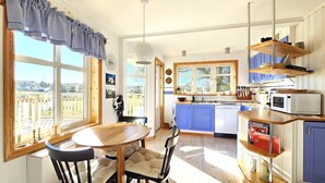 A bright kitchen with a dining area, large windows, and a view of the countryside. - Family-friendly house close to sea & nature in Klövedal | SE09145 (Klövedal)