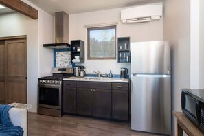 A modern kitchen with a stove, oven, sink, and stainless steel refrigerator.