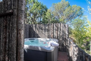 A hot tub surrounded by a wooden fence with trees in the background. - Cerro de la Paz (Santa Fe)