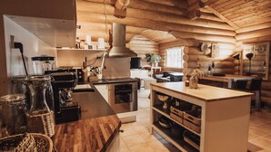 A modern kitchen with wooden cabinetry, stainless steel appliances, and a central island. - 5 Star Holiday Home in Jaegerspris (Jægerspris)