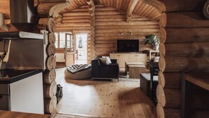 A log cabin interior with a kitchen, living area, and a dining space. - 5 Star Holiday Home in Jaegerspris (Jægerspris)