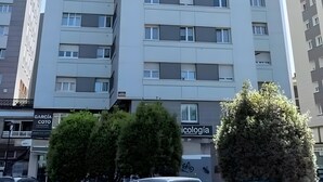 A multi-story building with balconies, a sign for 'García Psicología,' and a tree in the foreground.