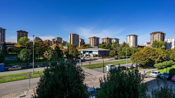 A cityscape with high-rise buildings, a pedestrian crossing, and a parking area.