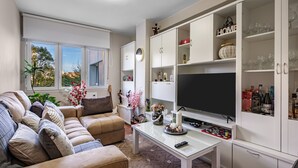 A living room with a sofa, TV, and cabinets.