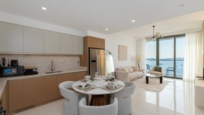 Een moderne keuken met een eethoek, een bank en uitzicht op zee.