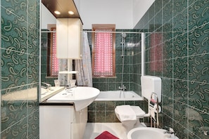 Une salle de bain avec une baignoire, des toilettes et un lavabo.