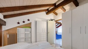 A bedroom with a bed, a wardrobe, a radiator, and a door leading to another room. - Apartment 'Trilocale 13' with Mountain View and Wi-Fi (Gressan)