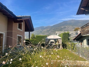 A residential area with houses, a gazebo, and a mountainous backdrop.