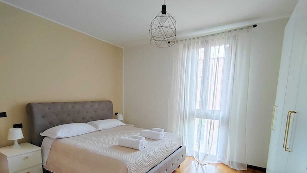 Une chambre à coucher avec un lit, une table de chevet et un luminaire suspendu.