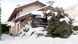 Un immeuble sur lequel on peut lire l’inscription « Au Petit Chevrolet Apartments », entouré de neige.