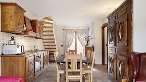 Una cocina con armarios de madera, una mesa de comedor y sillas.