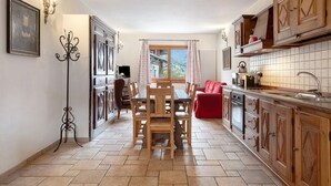 Una cocina con armarios de madera, una mesa de comedor y vistas al exterior.