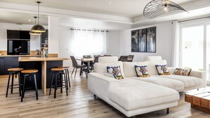 Una sala moderna con un conjunto de sofás, un comedor y una cocina.